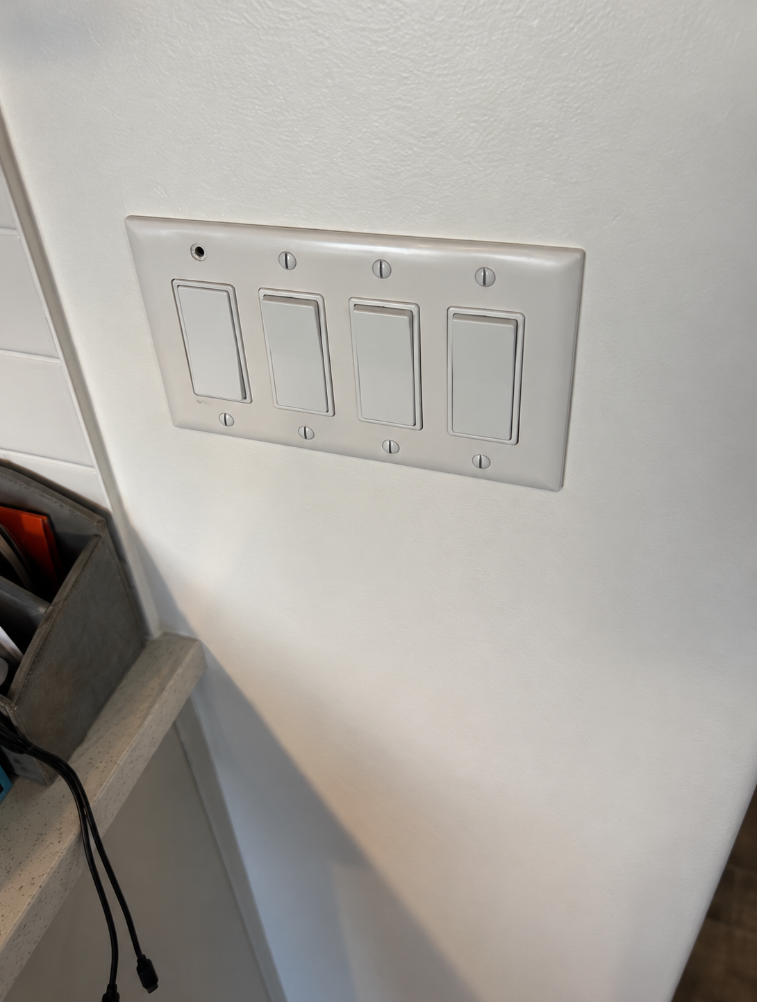 Correction photo of a kitchen switch plate missing a screw